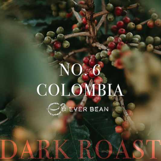 Nærbillede af kaffeplantens grene med røde og grønne kirsebær. Hvid tekst siger "No. 06 · Colombia Dark Roast" og "EverBean", hvilket antyder, at dette er en premium colombiansk kaffe fra EverBean-mærket.