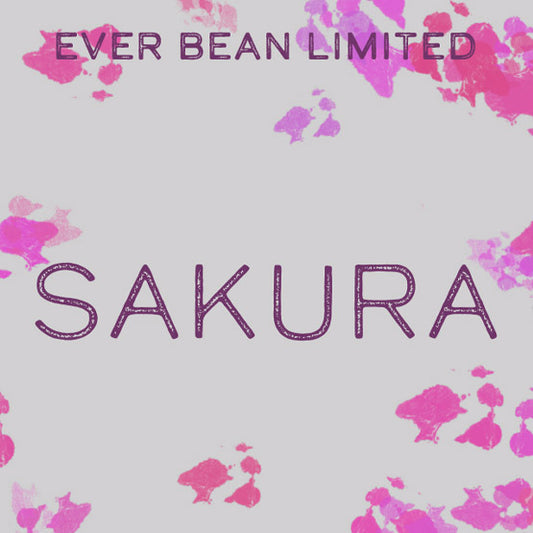 Ordene "EverBean Wholesale" og "Limited, Sakura (øko) (w)" står i lilla på en lys baggrund med pink og lilla blomsterstænk, som afspejler den delikate skønhed i denne 100 % arabica Sakura-kaffe.