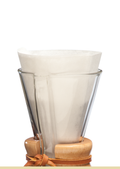 En Chemex kaffebrygger i glas med trækrave og læderbånd vises med en tom, foldet Chemex Kaffefiltre 3-kop (FP-2) placeret i den øverste åbning.