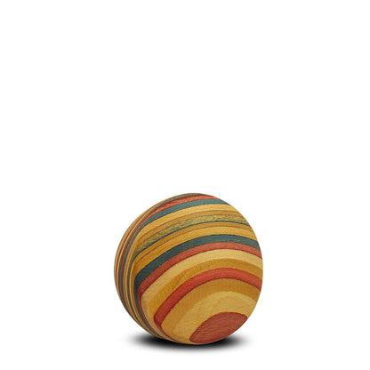 Comandantes Skateboard Creations fremviser en bæredygtig knop-trækugle med livlige, lagdelte striber af gul, orange, rød og grøn på en hvid baggrund, der kaster en subtil skygge.