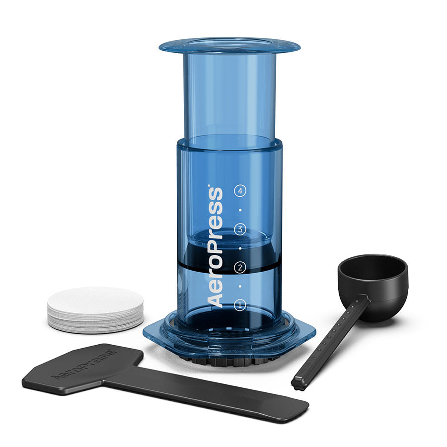 En blå AeroPress, Limited, Kaffebrygger by Aeropress med stempel, øse, omrører og runde papirfiltre på en hvid baggrund-perfekt bærbar bryggeteknologi til kaffeelskere.