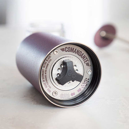 Nærbillede af Comandante C40 MK4 Nitro Blade, Deep Purple håndkværn. Justeringsknappen, de markerede maleindstillinger og stålkværnbladet er synlige gennem den matte og metalliske finish, når kværnen ligger på siden.