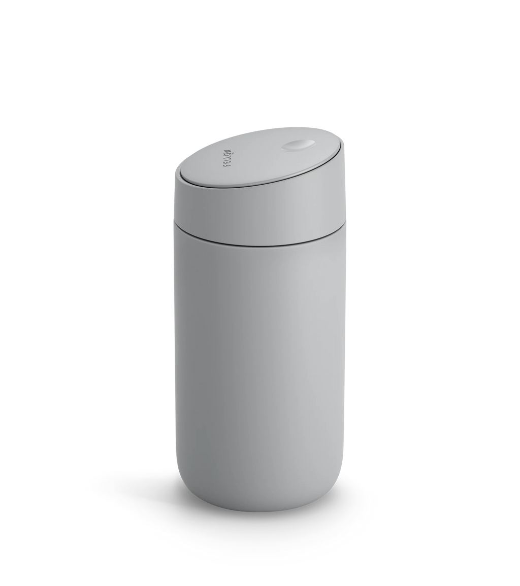 Fellow Carter Slide Mug er et stilfuldt mat gråt rejsekrus med et afrundet låg, glide-låg og varmelåsende dobbeltvægget vakuum-design, der forstærker dets moderne look og holder din drink varm.