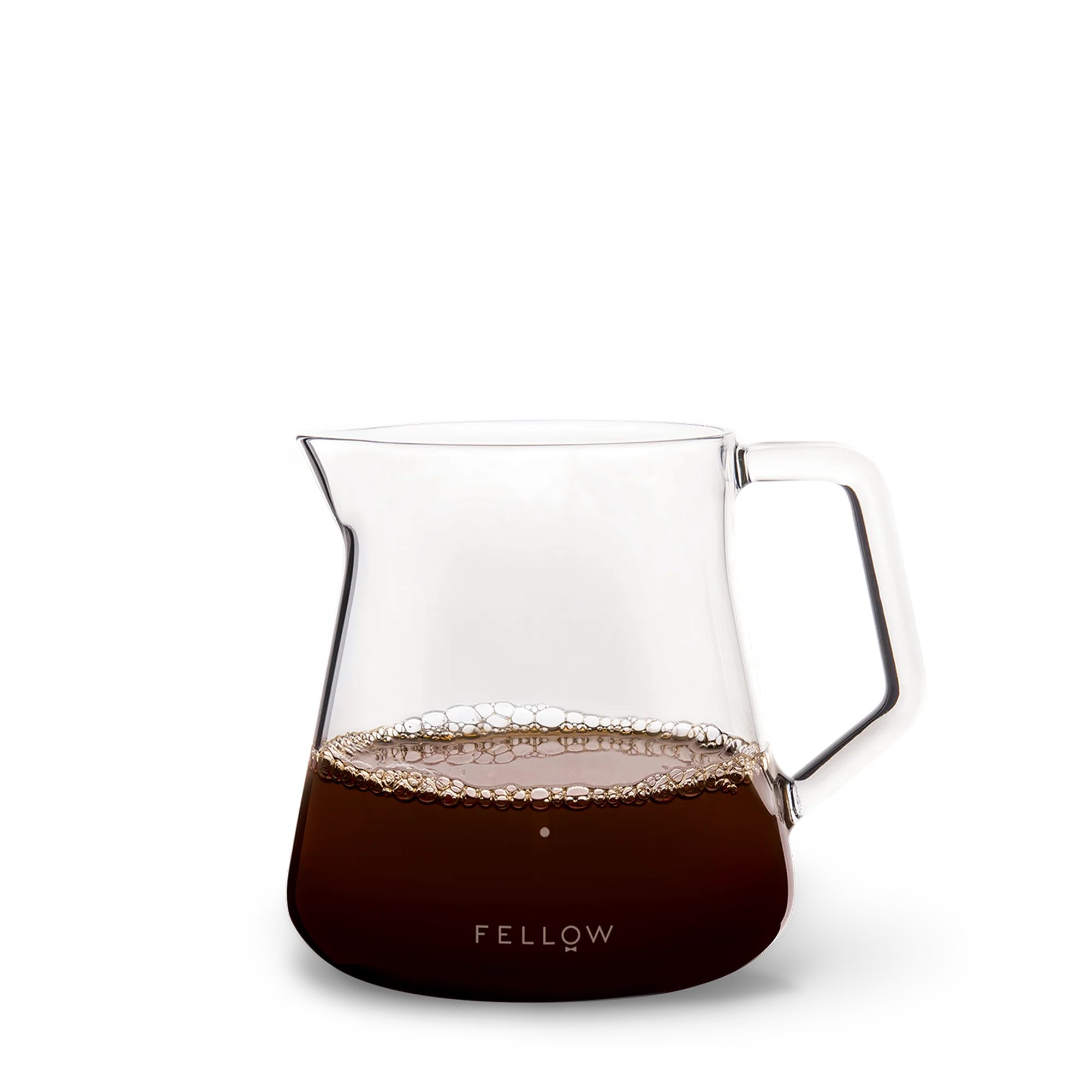 The Fellow Mighty Small Glas Karaffel, halvt fyldt med kaffe og bobler, passer perfekt sammen med Stagg [X] Drypperens for et ideelt kaffe-til-vand forhold. Den har en bred tud, robust håndtag og "Fellow" i hvid på en sort base.