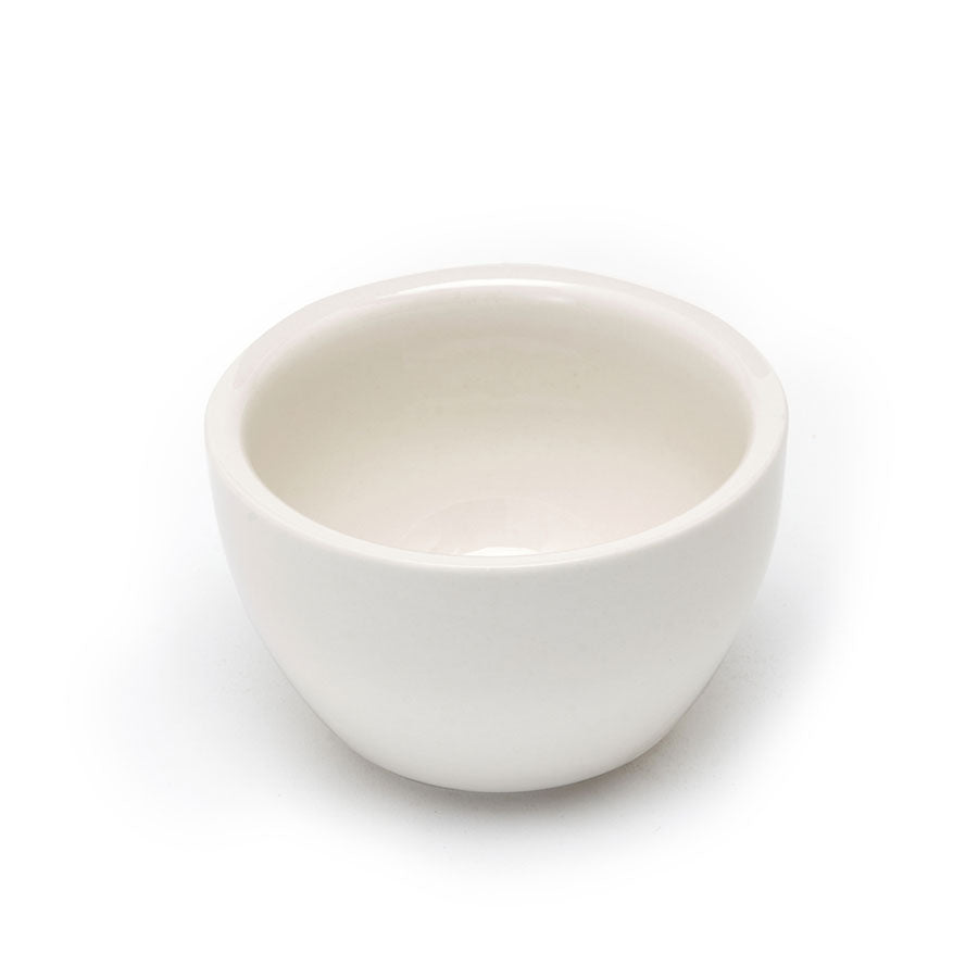Rhino Coffee Gear Cupping Skål er en lille hvid keramisk skål med en blank finish, med en glat overflade og afrundet form. Den sidder på en hvid baggrund og fremhæver dens højkvalitets keramiske håndværk.