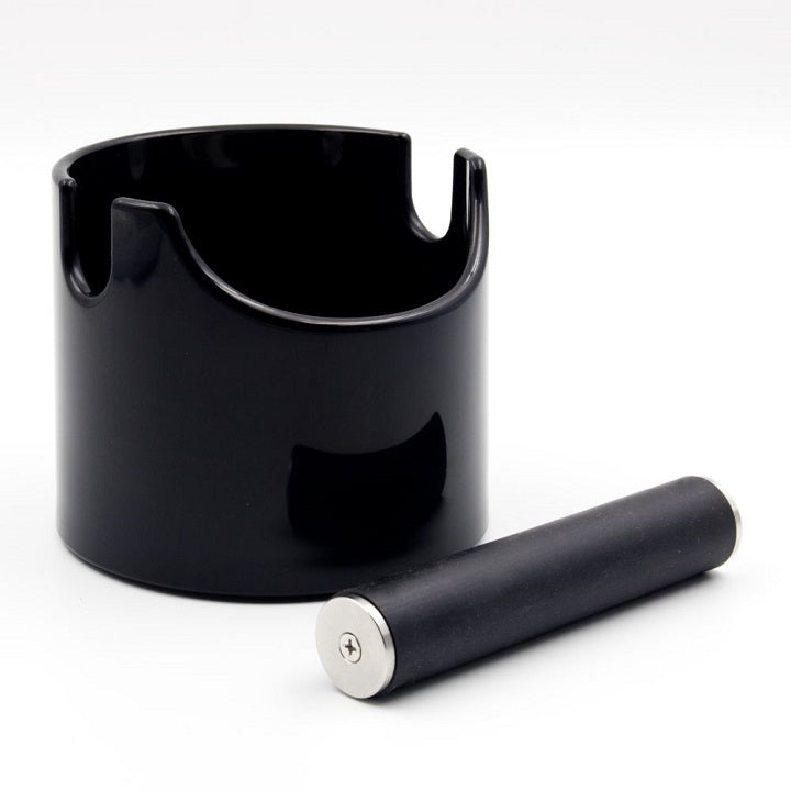 En sort cylindrisk beholder, Rhino Coffee Gear Mini Waste Bin, Sort, med en udskæring, sidder på en hvid overflade. Ved siden af er en separat gummistang med metalliske ender.