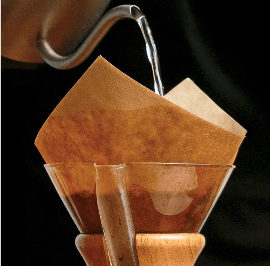 Varmt vand hældes over et papirfilter i en Chemex bryg pakke 2 fra EverBean ApS. og starter pour-over kaffebrygningsprocessen.