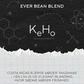 På en kaffeetiket står der "KeHo" fra EverBean. Baggrunden viser kemi- og videnskabssymboler i kridtstil. Nedenunder står der: "Costa Ricas bjerge møder Tanzanias - i en livlig kaffeblend, hvor sødme møder friskhed.