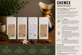 EverBean ApS. Chemex Smagspakke med trækrave sidder ved fire kaffeposer - nr. 3, nr. 5, Sakura og nr. 7 - ideel til at brygge filterkaffe og smage de rene kaffenoter, omgivet af bønner, kopper og grønne blade.
